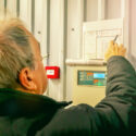 Engineer inspecting fire alarm panel