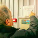 engineer inspecting fire alarm panel