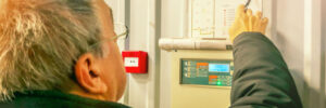 Engineer inspecting fire alarm panel