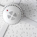 modern smoke detector on commercial ceiling indoors