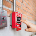 Hand of woman reaching to Fire alarm switch system