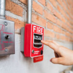 Hand of woman reaching to Fire alarm switch system