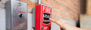 Hand of woman reaching to Fire alarm switch system