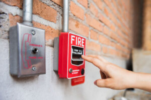 Hand of woman reaching to Fire alarm switch system